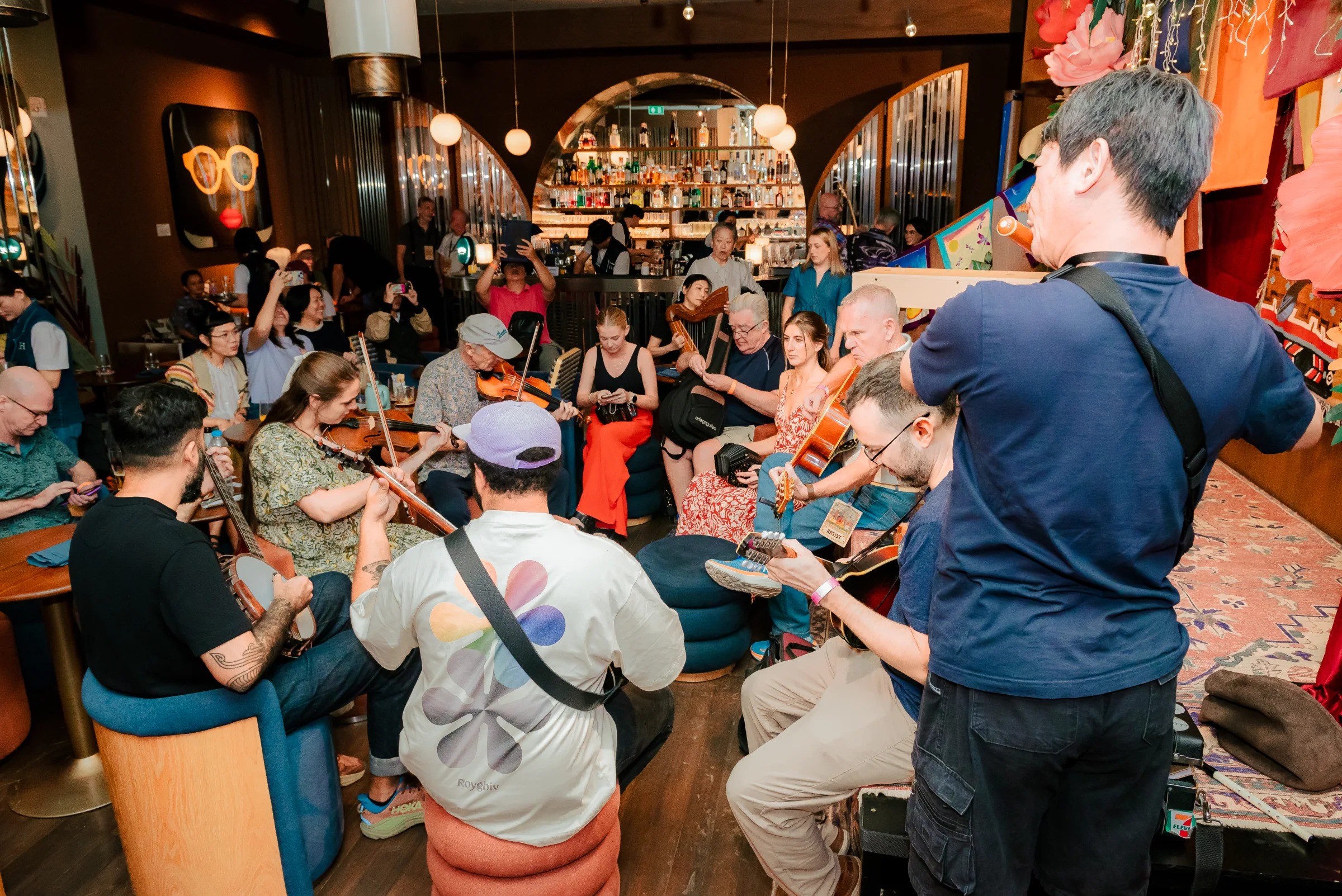 A crowded jam circle filling Public House in front of the arched bar